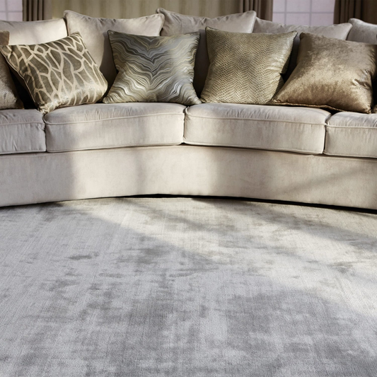 Beige sectional sofa with patterned cushions on a textured gray rug.