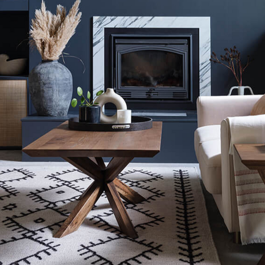 Modern living room with a fireplace, sofa, and decorative items.