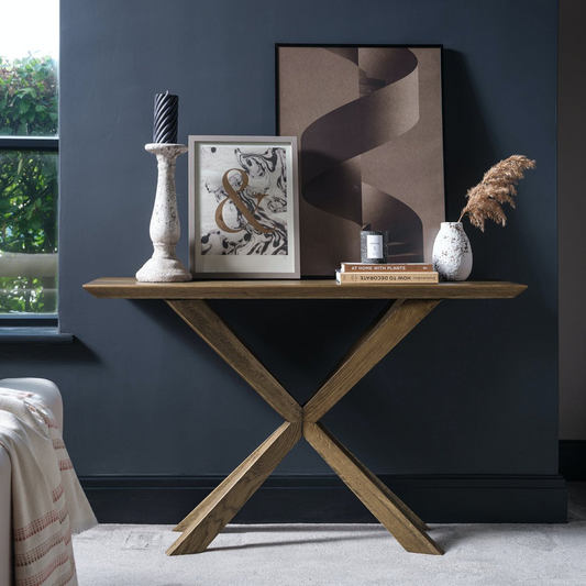 Wooden console table with decorative items against a dark blue wall