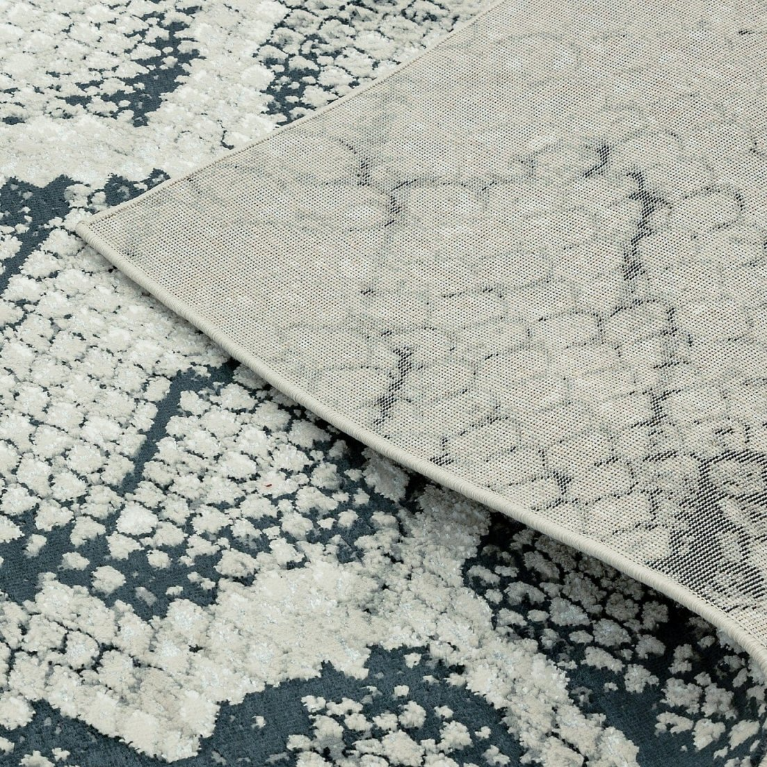 Close-up of a gray and black snakeskin patterned rug corner