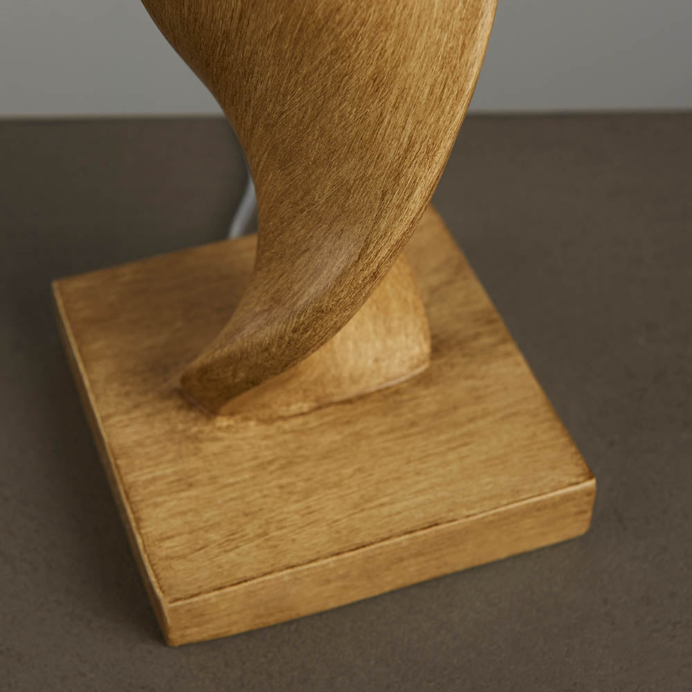 Wooden lamp on a square base against a neutral background