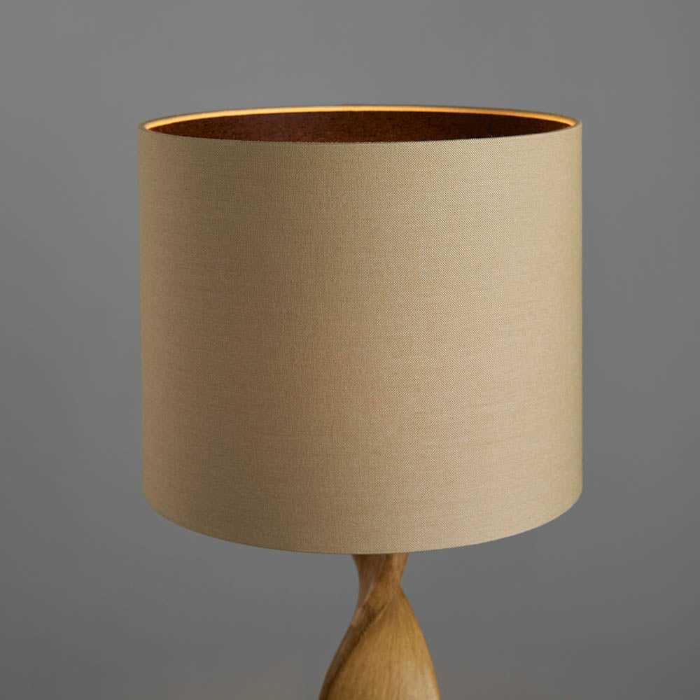 Beige lampshade on a wooden base against a gray background