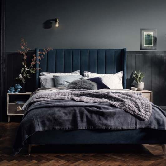 Dark-themed bedroom with a bed and decorative elements.