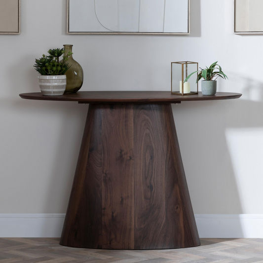 Wooden console table with decorative items against a neutral wall