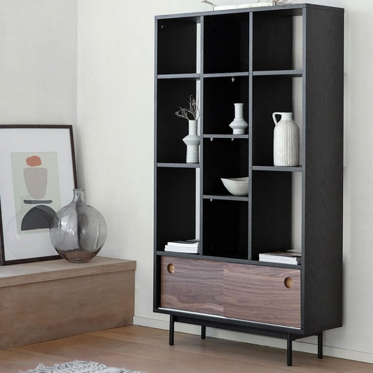 Modern black and wood bookshelf with decorative items in a room setting.