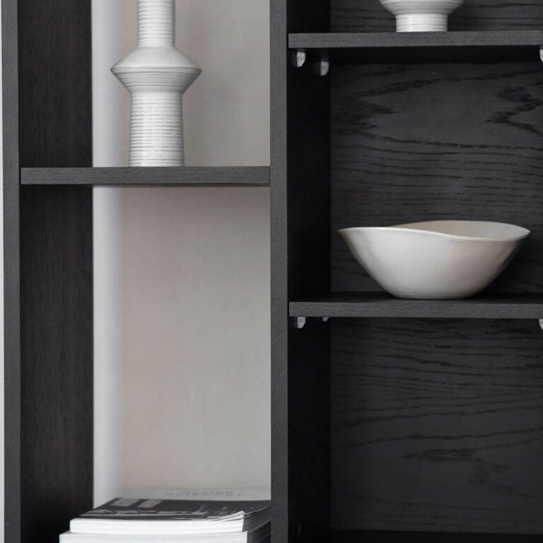 Dark wooden shelves with white ceramic bowls and a magazine.