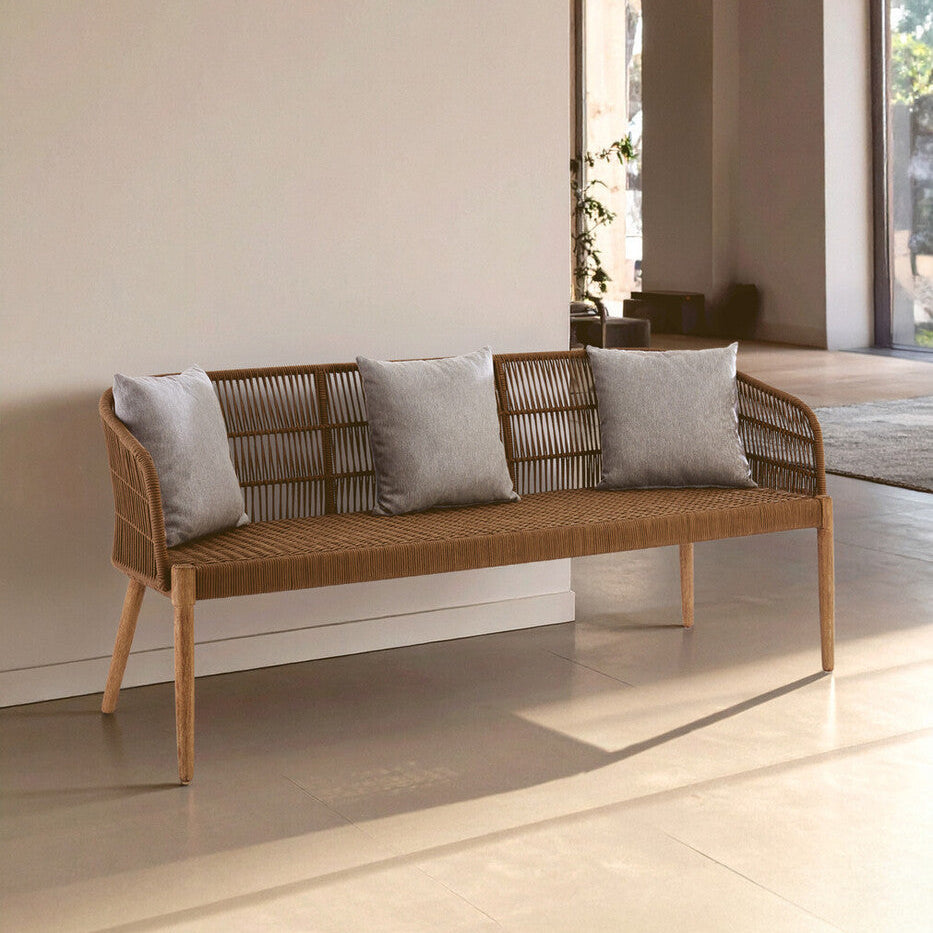Wicker bench with gray cushions in a modern indoor setting