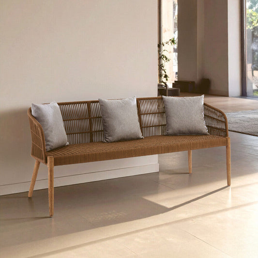 Wicker bench with gray cushions in a modern indoor setting