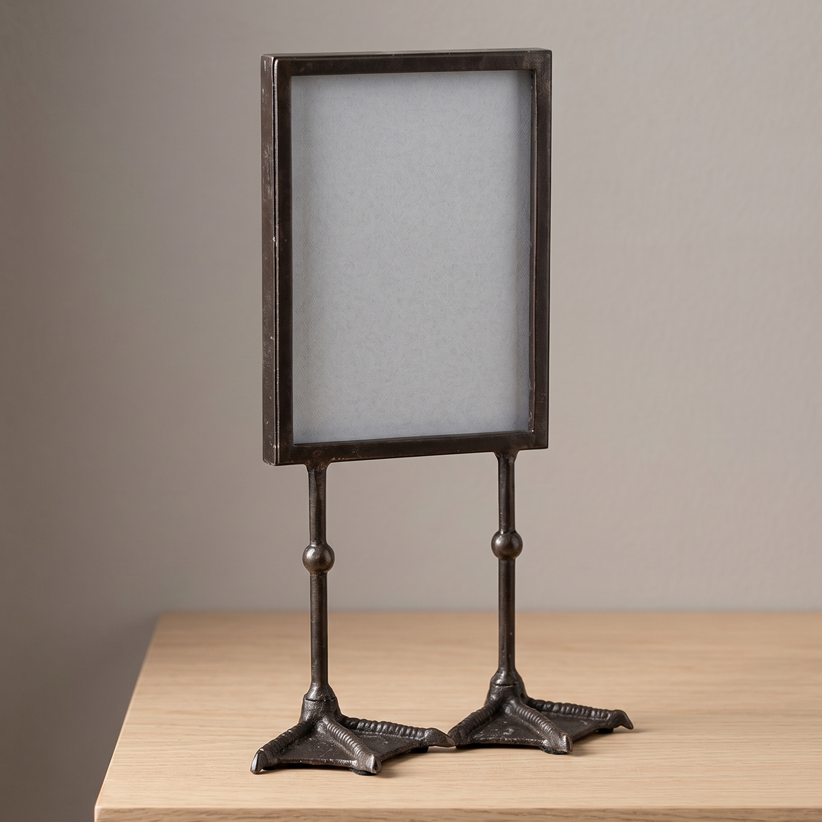 Decorative metal picture frame on a stand with a neutral background