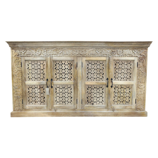 A large, hand-carved solid wood sideboard measuring 190cm wide by 101cm high, featuring four intricately detailed doors with metal handles. The natural rustic finish highlights the ornate floral and geometric carvings, adding a touch of artisanal craftsmanship. Behind the doors are two spacious cupboards with internal shelves, offering ample storage. The wide counter-top provides additional surface space, making this piece both functional and decorative for various interior settings.