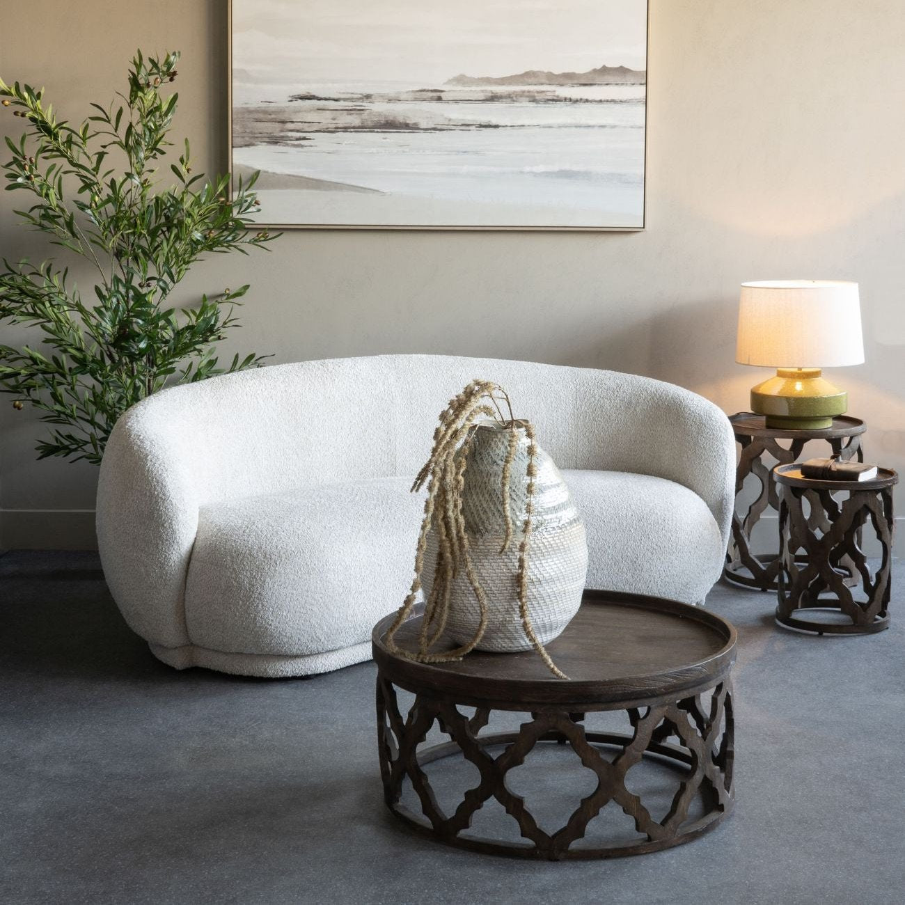 Curved Ivory Boucle Textured Sofa Photo In Room with Warm Lighting and Potted Plant