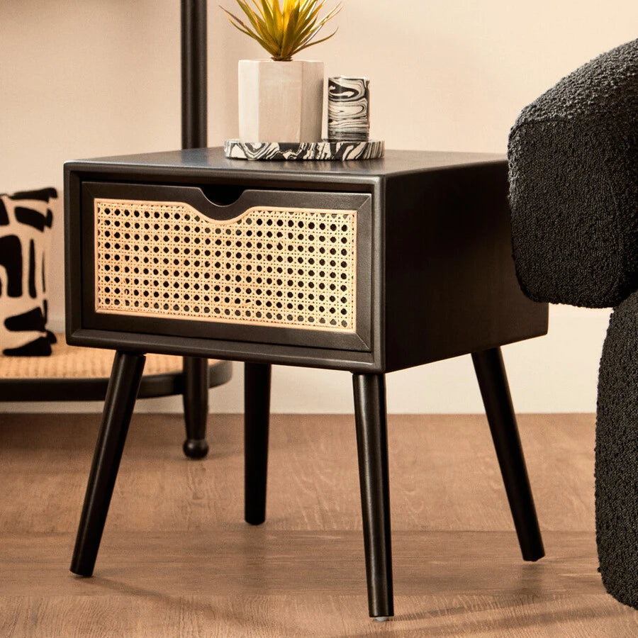 Black side table with wicker drawer in a room setting