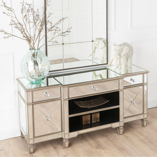 Decorative console table with mirror and decorative items in a room.