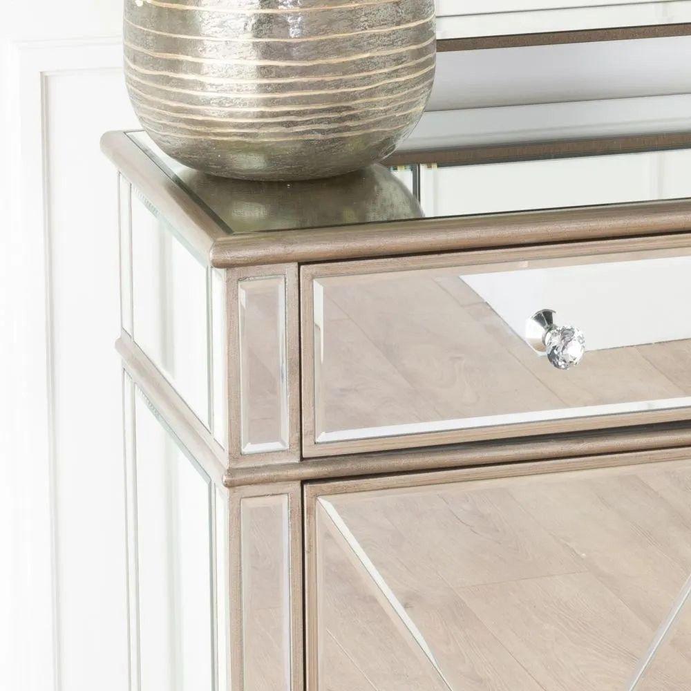 Decorative mirror with reflective surface and a vase on top