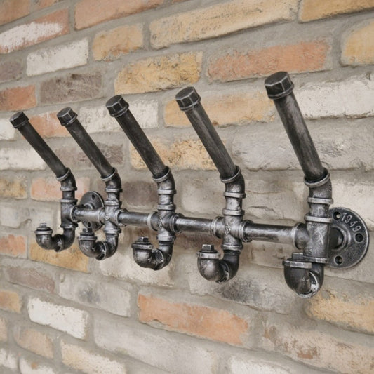 Decorative wall hook made of metal pipes on a brick wall