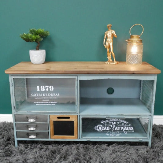 Furniture piece with wooden top and metal base against a teal wall.