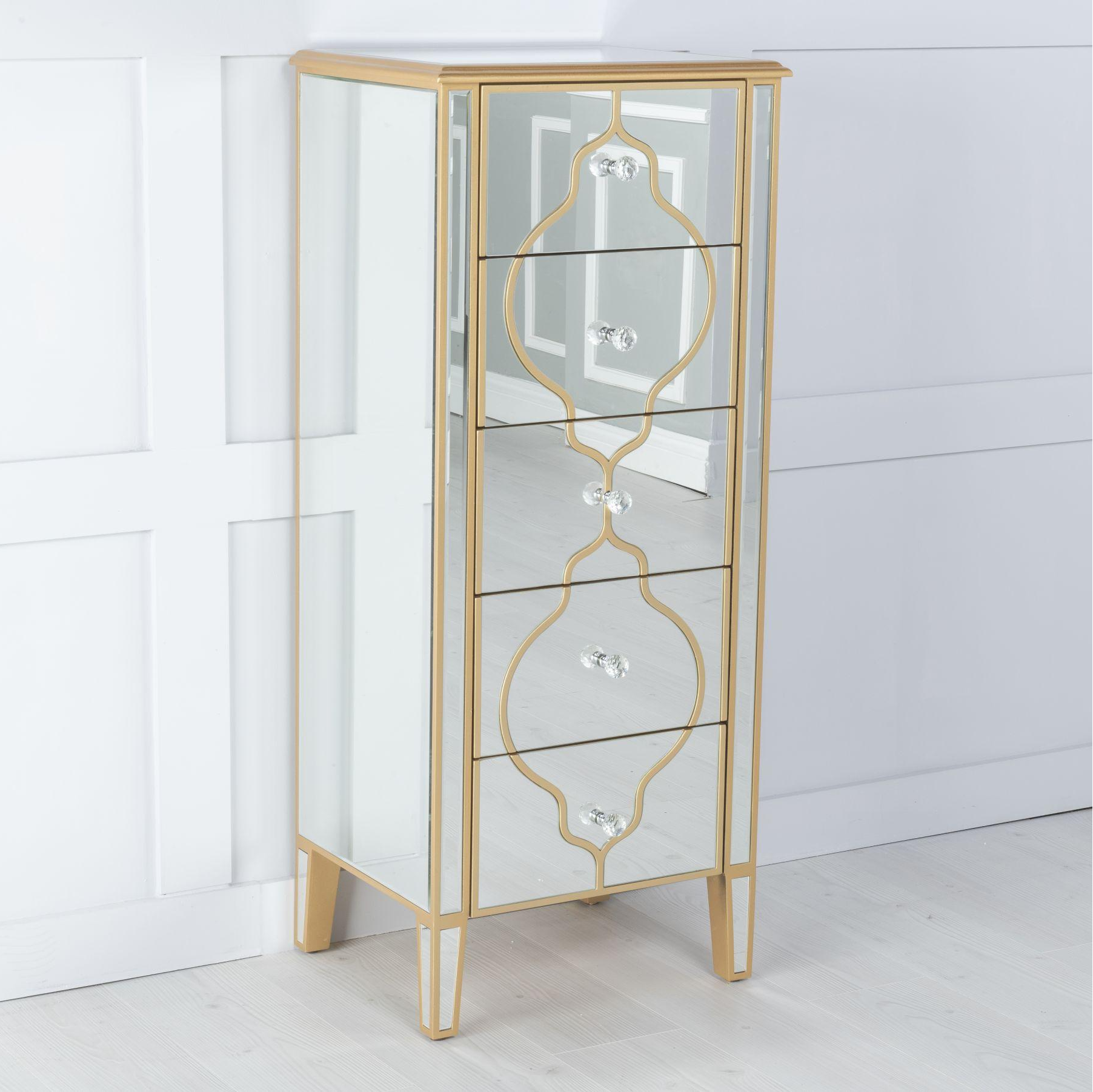 Tall, narrow cabinet with gold mirror accents on a white background