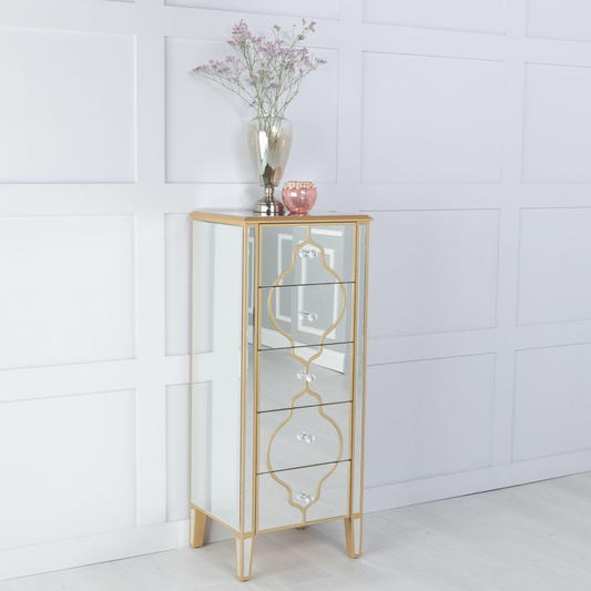 Gold-framed glass cabinet with decorative items against a white paneled wall.