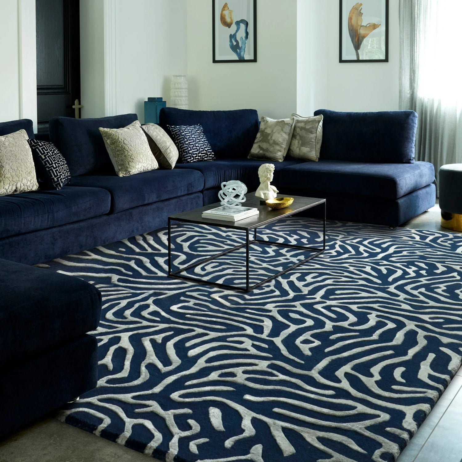 Modern living room with a navy sectional sofa and patterned rug.