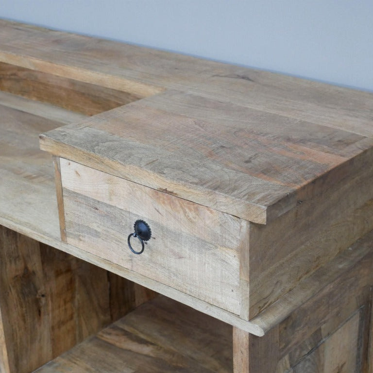 Elevate your entertaining space with this daring Rustic Mango Wood Bar Cabinet! Crafted from solid mango wood, its boho rustic charm is enhanced textured, natural details and bold black stamped accents that bring a unique edge. Featuring two spacious drawers, open shelves, and built-in wine racks, it offers generous storage to showcase your finest spirits and glassware. Ideal for rustic, boho, coastal interiors!