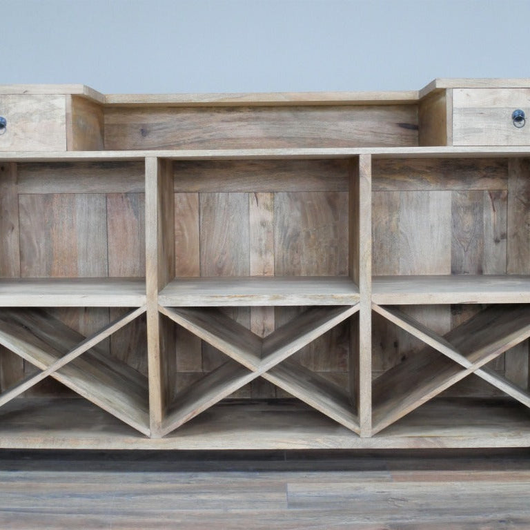 Elevate your entertaining space with this daring Rustic Mango Wood Bar Cabinet! Crafted from solid mango wood, its boho rustic charm is enhanced textured, natural details and bold black stamped accents that bring a unique edge. Featuring two spacious drawers, open shelves, and built-in wine racks, it offers generous storage to showcase your finest spirits and glassware. Ideal for rustic, boho, coastal interiors!