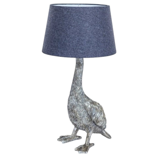 A quirky silver table lamp in the shape of a goose, with a dark blue lampshade.