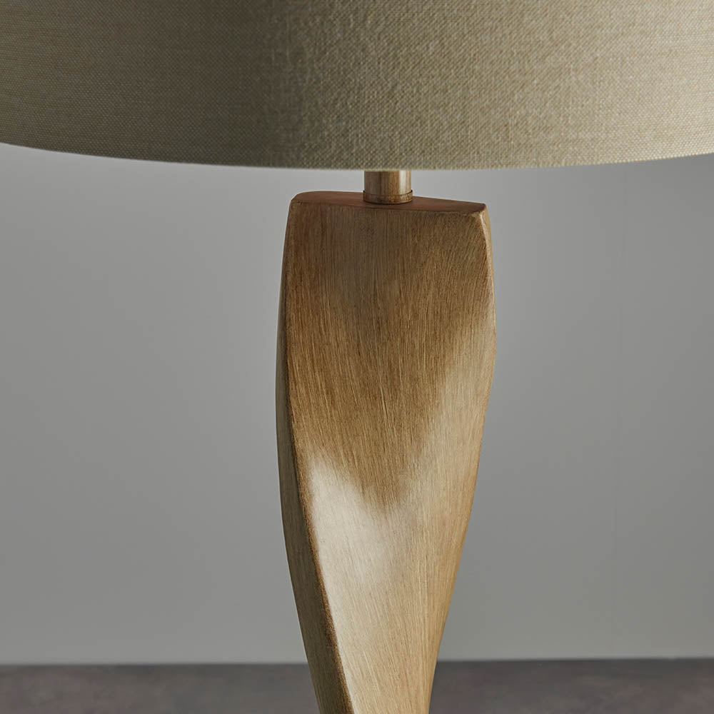 Close-up of a lamp with a wooden base and beige lampshade on a gray background