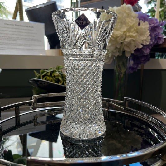Crystal vase on a reflective surface with blurred background