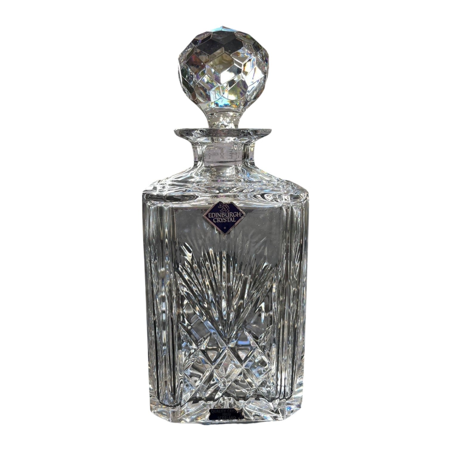 Crystal decanter with intricate design on a white background
