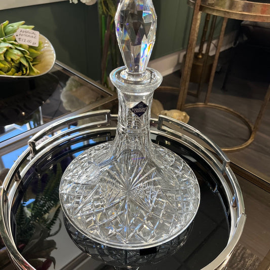 Crystal decanter on a silver tray with a blurred background