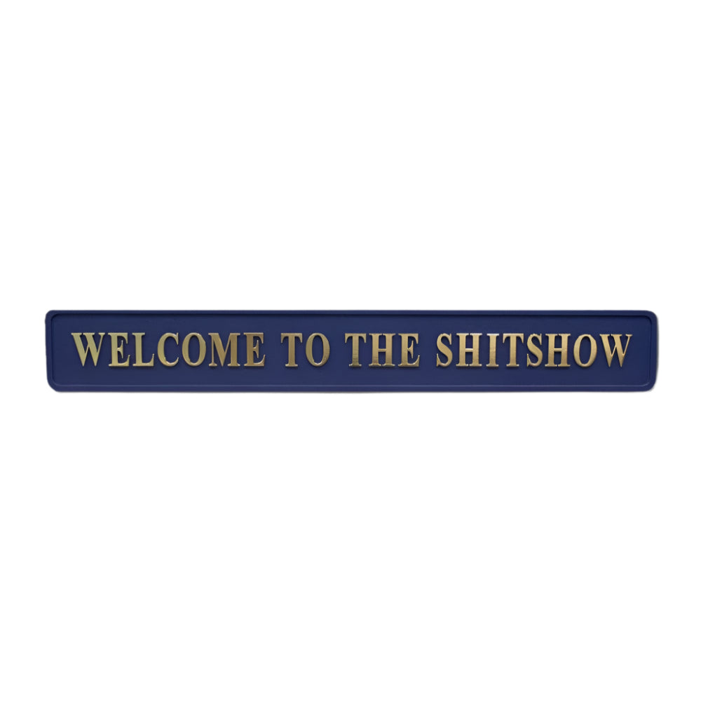 Blue wooden sign with gold text reading 'welcome to the shit show'