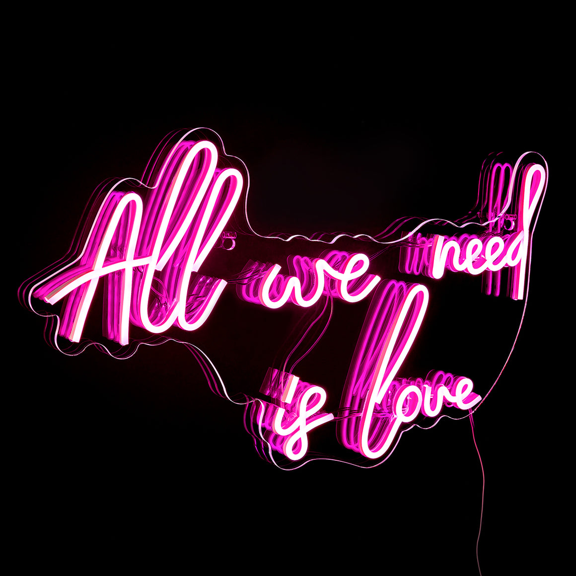 Neon sign with 'All we need is love' text on a black background
