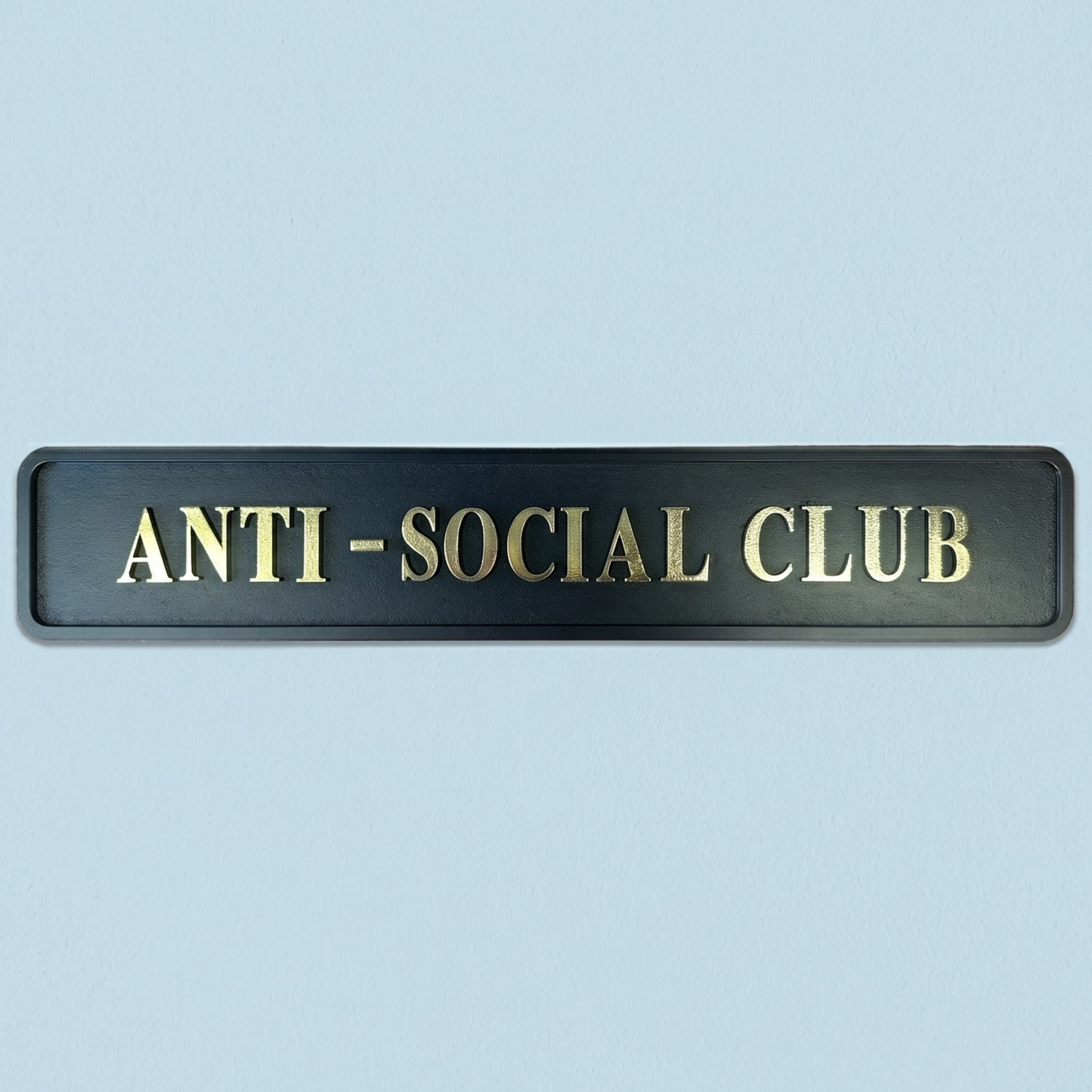 Black plaque with 'ANTI-SOCIAL CLUB' text on a light blue background
