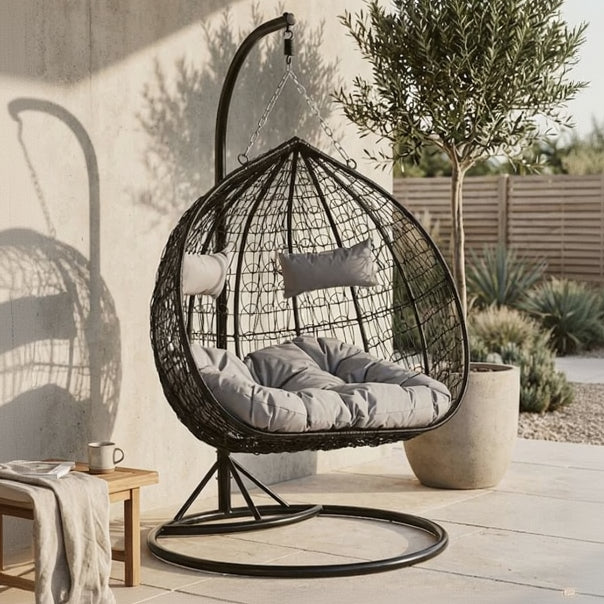 Wicker egg chair with cushions on a wooden deck