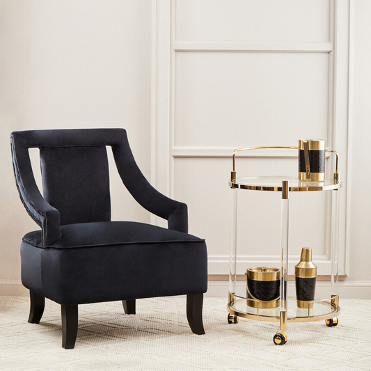 Black armchair in a room with a gold side table and decorative items.