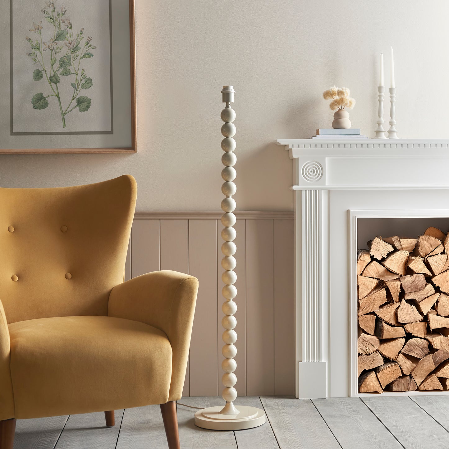 Living room with a yellow armchair, ivory base lamp and fireplace with wood.
