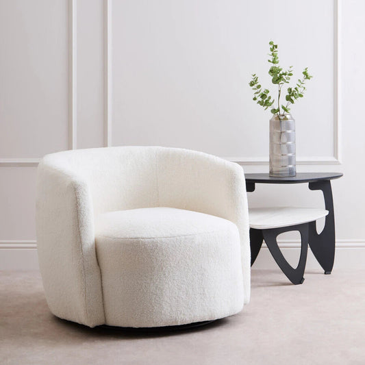White swivel chair in a minimalistic room with a plant on a side table.