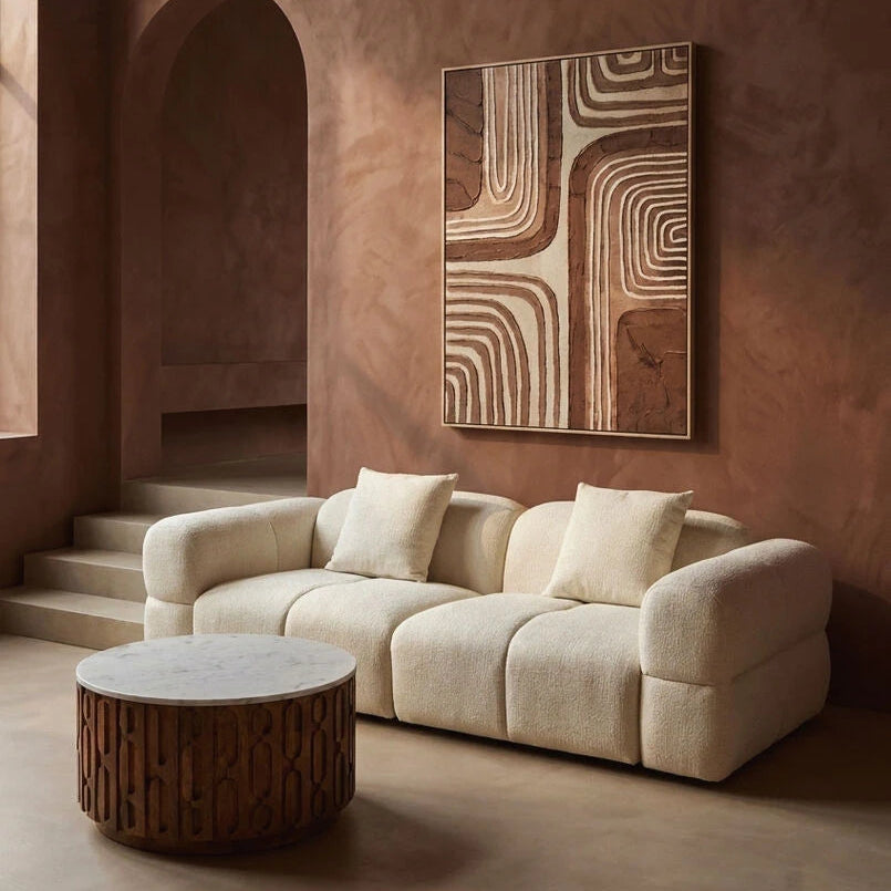 cream sofa in a room with a textured wall and abstract art