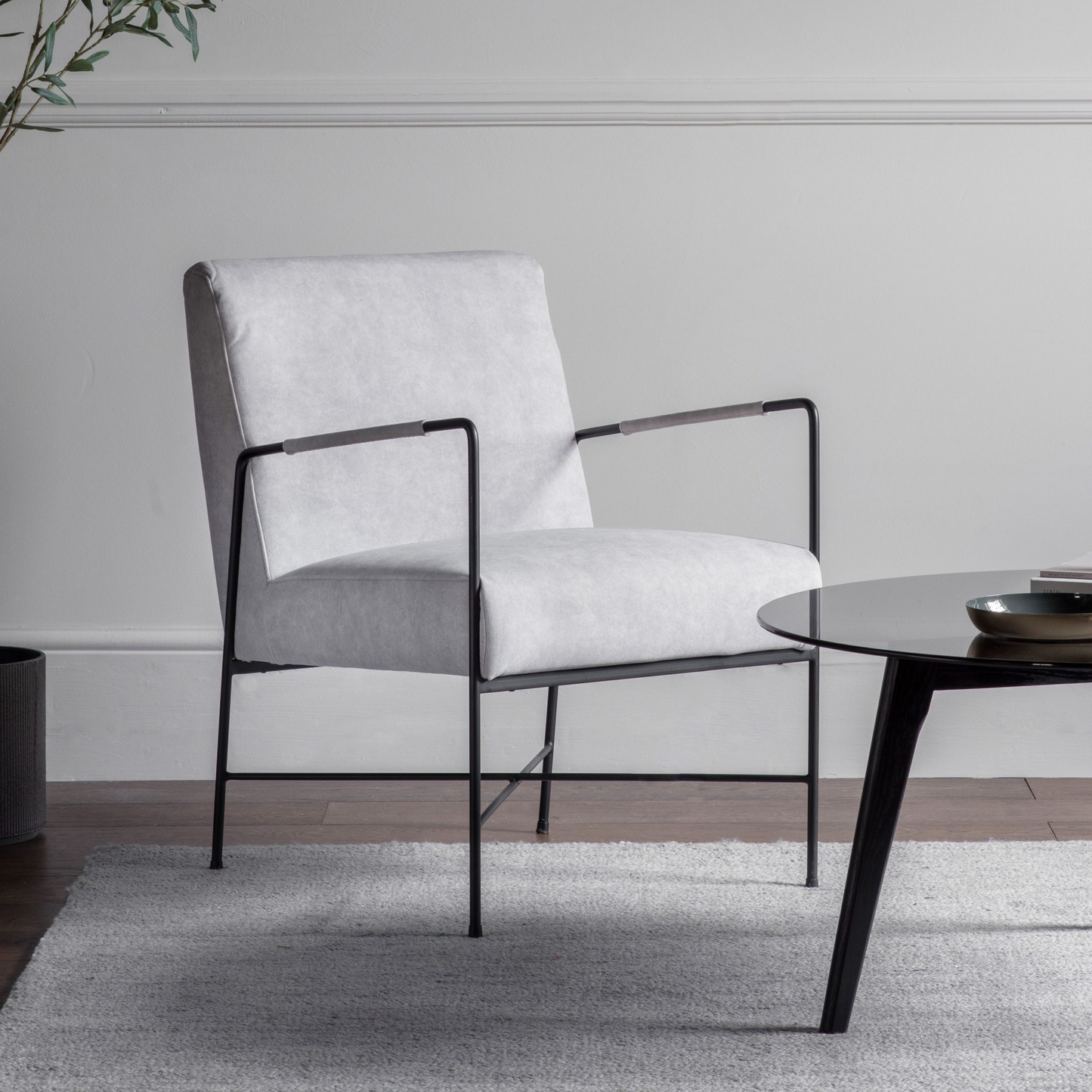 Modern white chair with black metal frame in a minimalistic room.