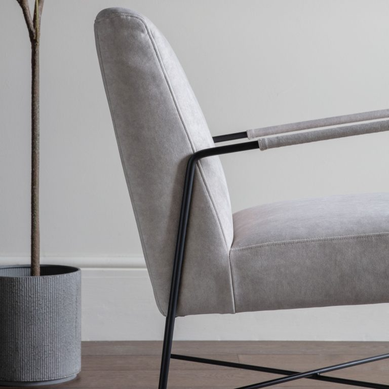 Gray armchair with black metal legs in a minimalistic setting