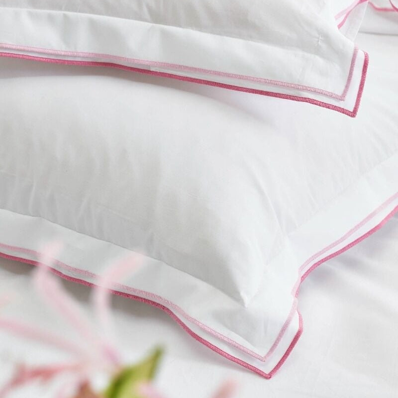 White pillows with pink piping on a white background