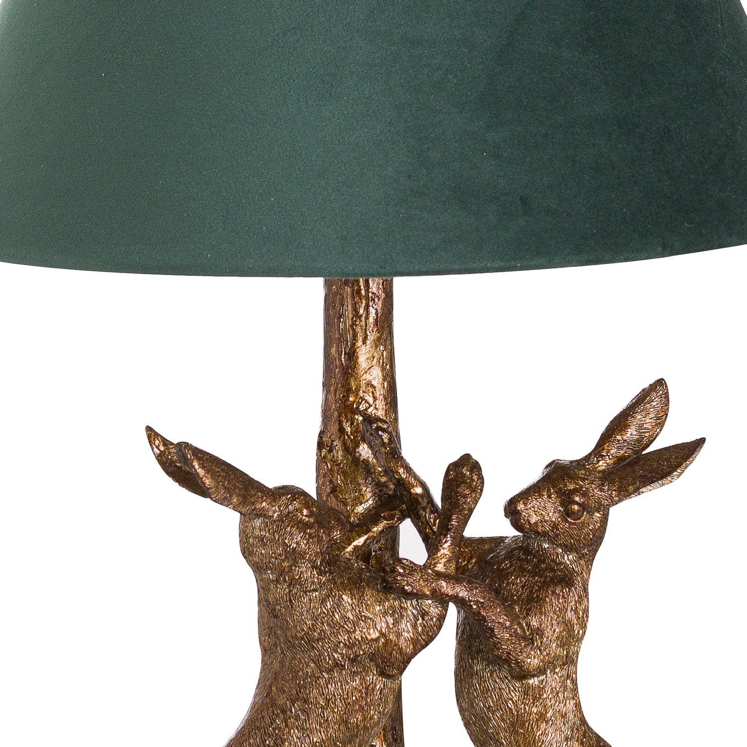Decorative lamp with bronze rabbit figures and a green lampshade on a white background
