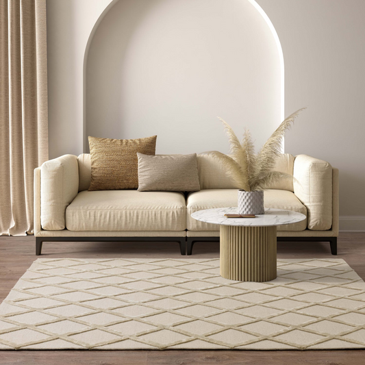 beige sofa with decorative pillows and a small table in a modern living room.