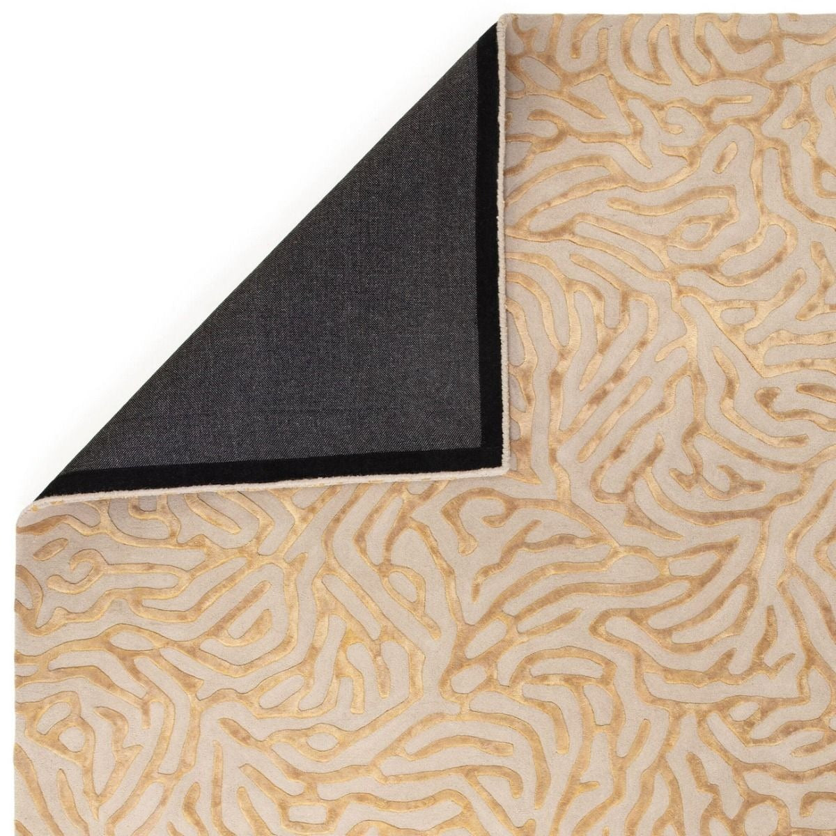 Corner of a rug with a gold and beige abstract pattern on a white background