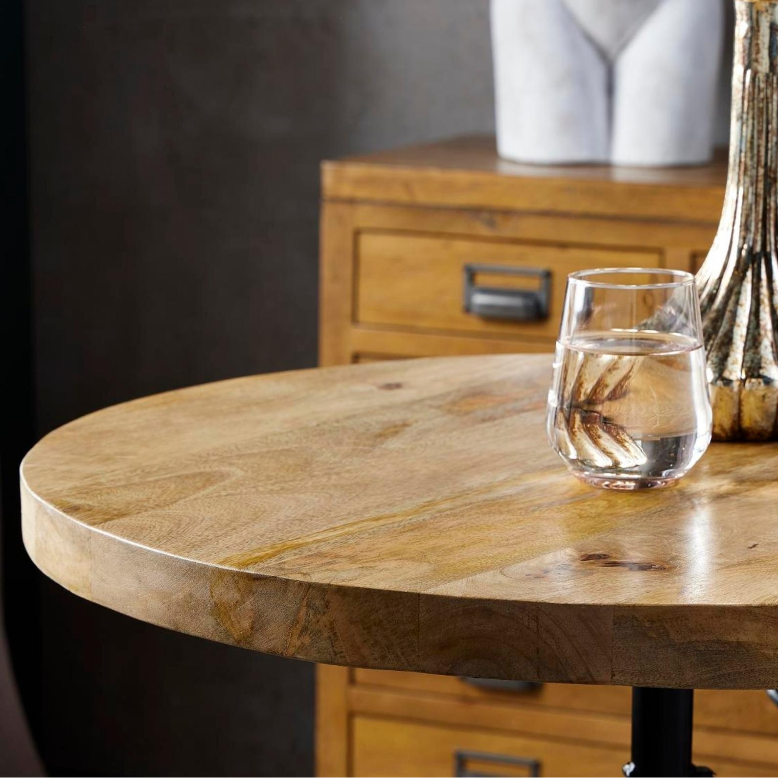 Glass of water on a wooden table with decorative elements in the background