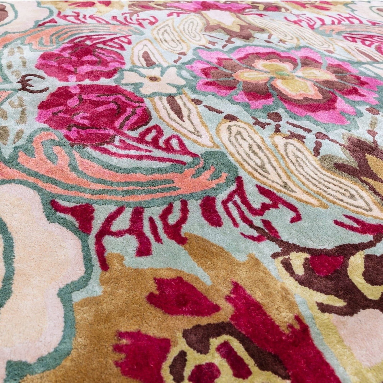 Close-up of a colorful floral patterned rug with vibrant pink, red, and gold colors.