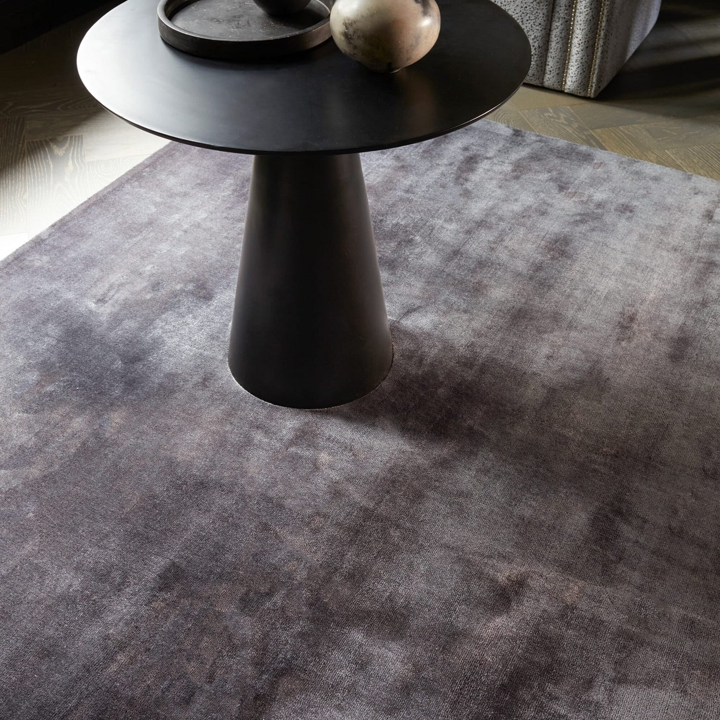 Black side table on a gray rug