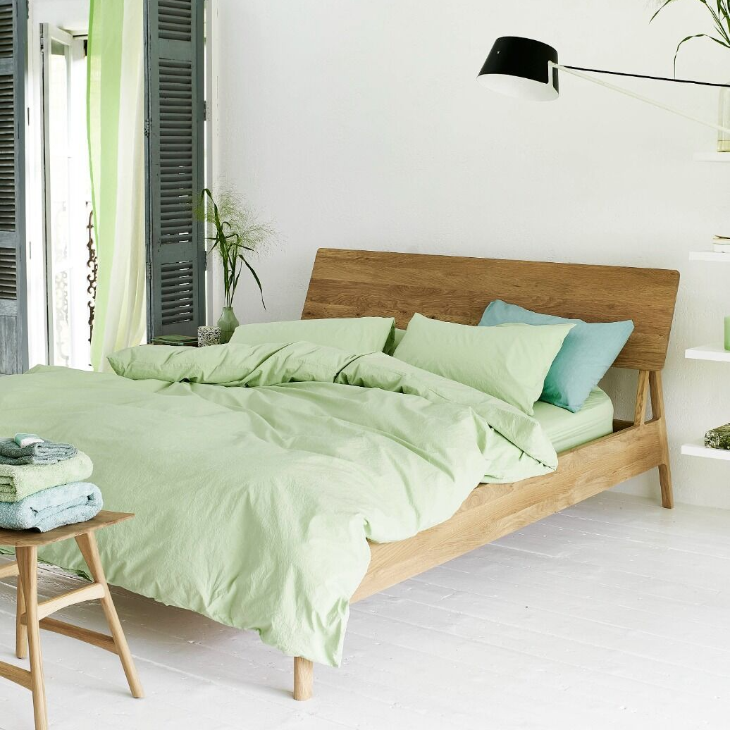 Bedroom with a wooden bed and green bedding
