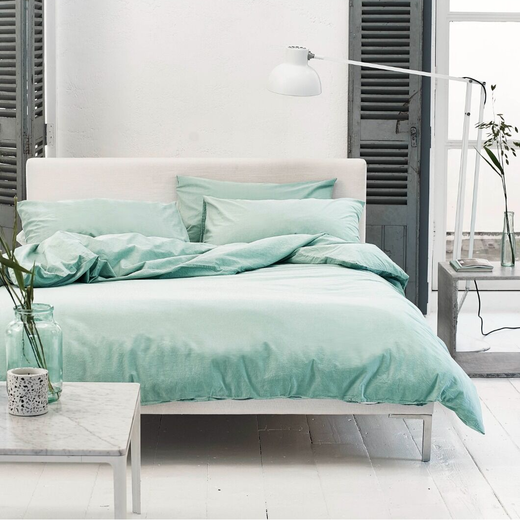 Bedroom with mint green bedding and white furniture
