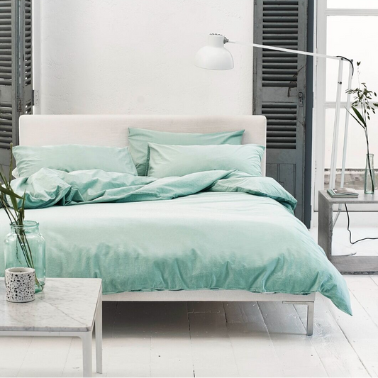 Bedroom with mint green bedding and white furniture